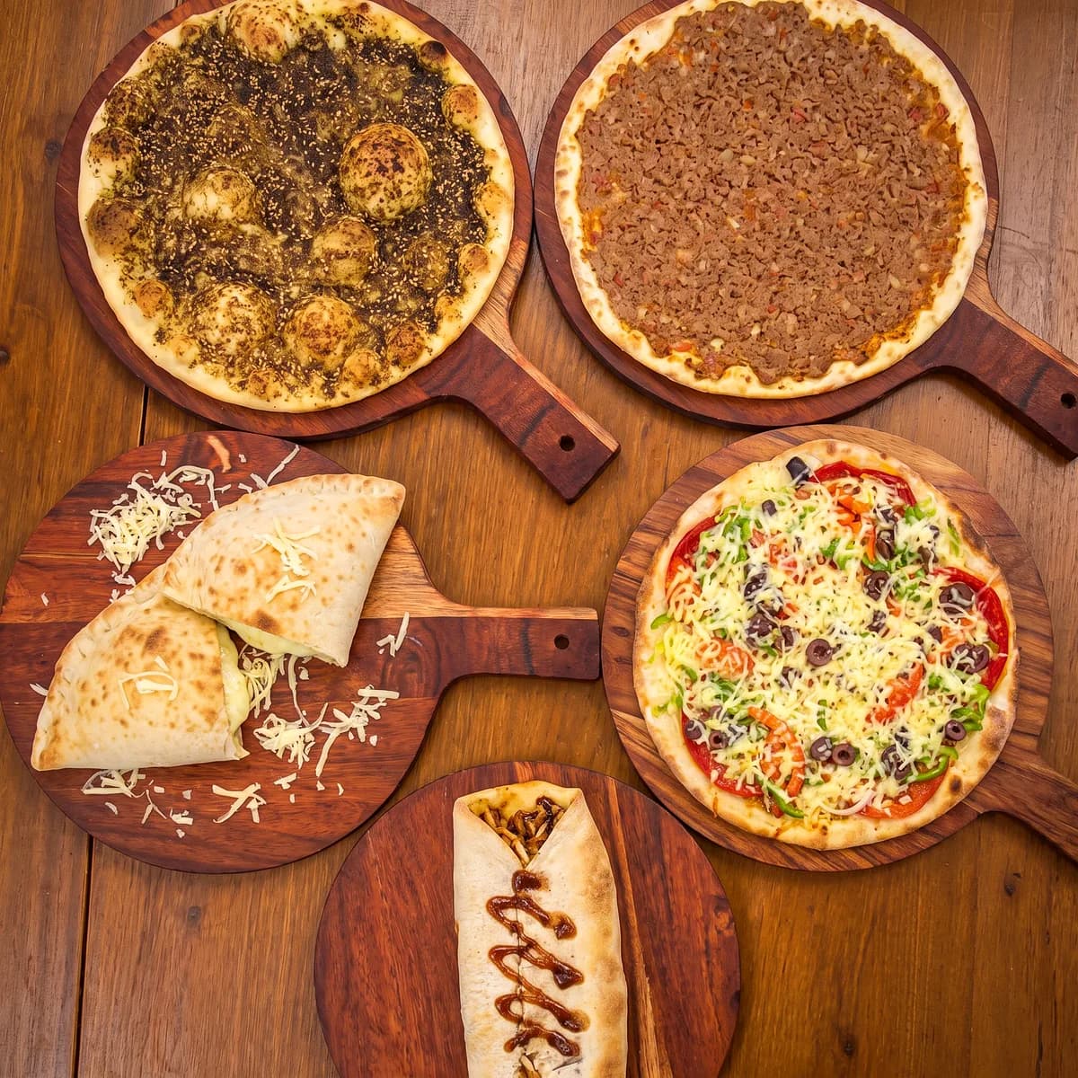 Zaatar, meat and cheese manoushe, a pizza and a wrap